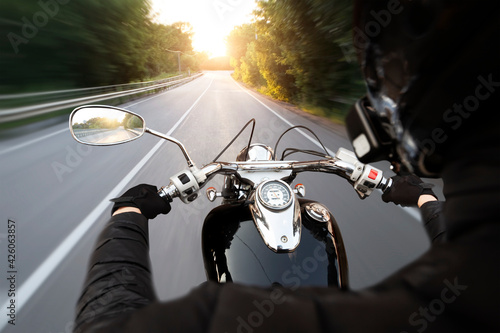 Foto The motorcyclist is riding through the empty asphalt road in the evening