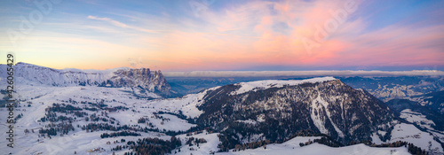 Sunrise over Sciliar Massif and Compatsch village covered with snow, aerial view, Seiser Alm, Dolomites, South Tyrol, Italy photo