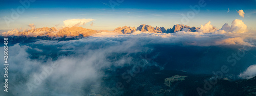 Aerial panoramic view of Brenta Dolomites emerging from clouds, Madonna di Campiglio, Trento, Trentino-Alto Adige, Italy