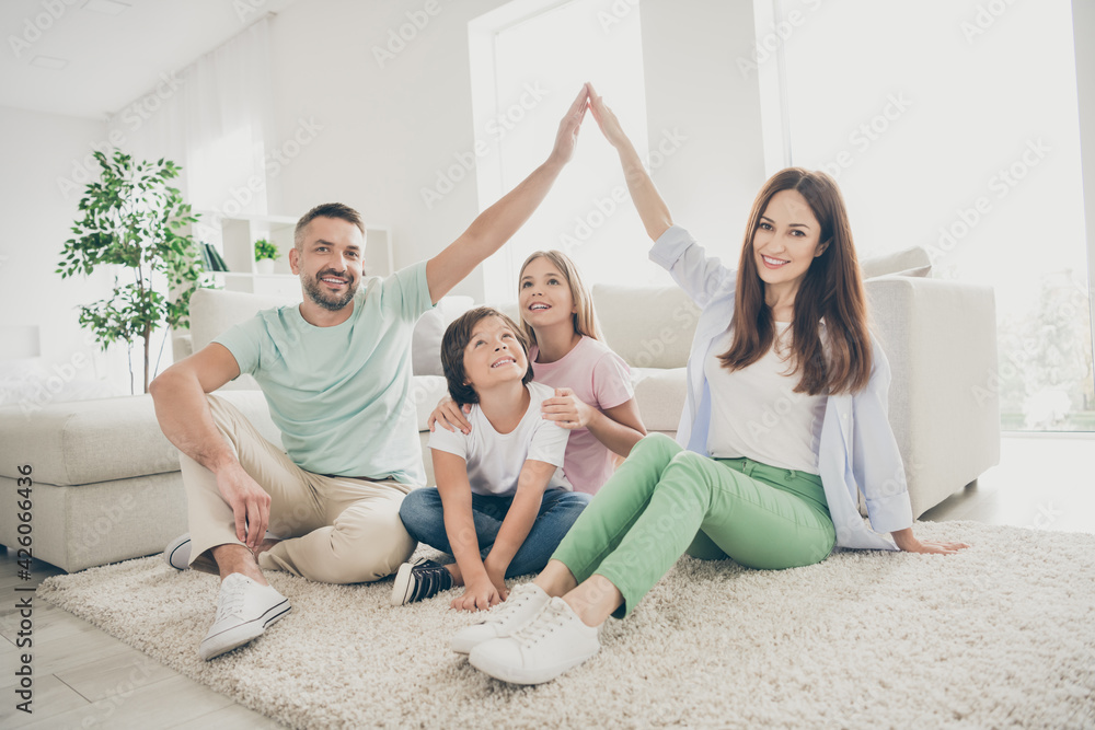 Full size photo of optimistic nice family mom dad two kids play show roof sit on floor wear t-shirts at home Full size photo of optimistic nice family mom dad two kids play show roof sit on floor wear t-shirts at home
