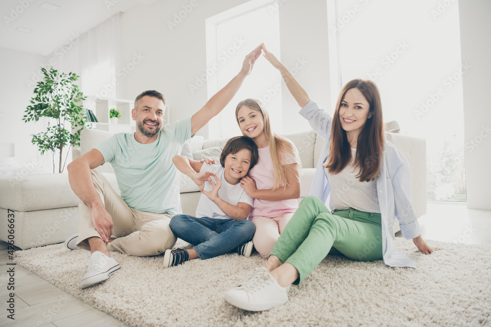 Full size photo of optimistic nice family mom dad two kids play show roof heart sit on floor wear t-shirts at home Full size photo of optimistic nice family mom dad two kids play show roof heart sit on floor wear t-shirts at home