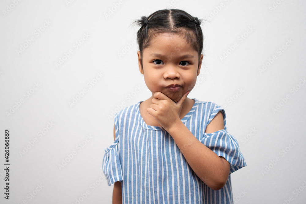 Portrait of Asian child 5 year old and to collect hair and Place her hands on her chin and make thinking pose on isolated white background, She is Happiness, radiance in youth, Education Concept Portrait of Asian child 5 year old and to collect hair and Place her hands on her chin and make thinking pose on isolated white background, She is Happiness, radiance in youth, Education Concept