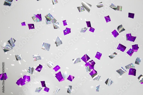 The party is over. Sweep the confetti off the floor. Purple and silver shiny confetti on a white floor.