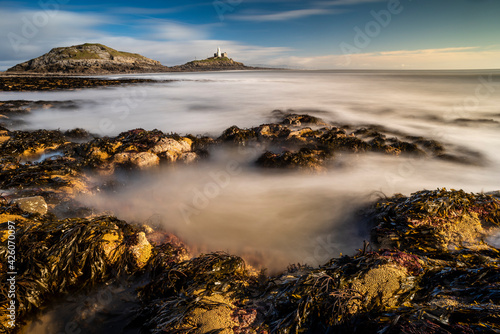 Tidal rock pools and Mumbles Lighthouse, Bracelet Bay, Mumbles Head, Gower Peninsula, Swansea, Wales, United Kingdom