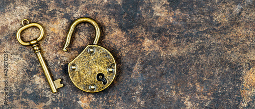 Escape room game concept, old vintage keys on and padlock on a rusty grunge metal background, web banner