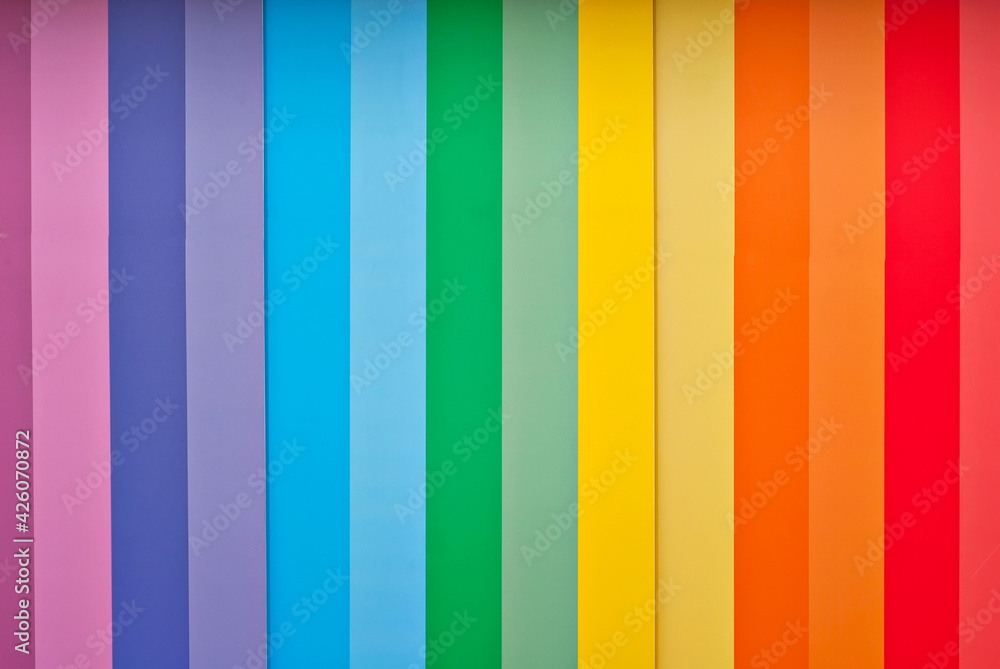 Multicolored strips of paper on the wall. Paper with rainbow colors. Interior design. Multicolored strips of paper on the wall. Paper with rainbow colors. Interior design.