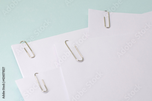 metal paper clips attached to a blank white paper