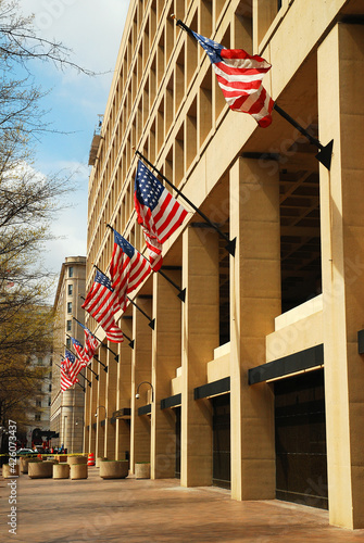 American Flag fly from the front of the FBI Headquarters building in Washington, DC photo
