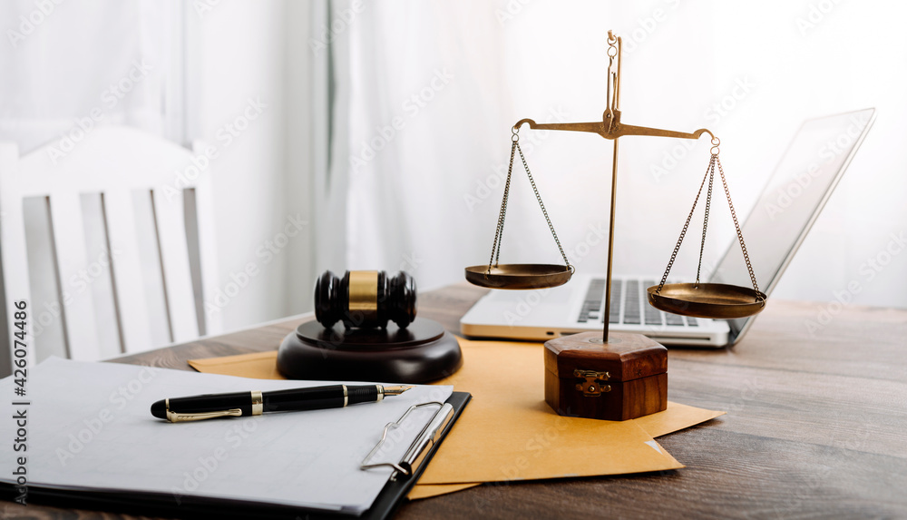 Business and lawyers discussing contract papers with brass scale on desk in office. Law, legal services, advice, justice and law concept picture with film grain effect Business and lawyers discussing contract papers with brass scale on desk in office. Law, legal services, advice, justice and law concept picture with film grain effect