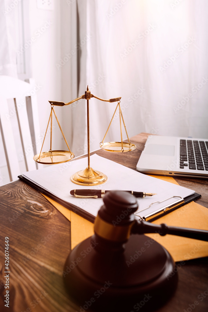Business and lawyers discussing contract papers with brass scale on desk in office. Law, legal services, advice, justice and law concept picture with film grain effect Business and lawyers discussing contract papers with brass scale on desk in office. Law, legal services, advice, justice and law concept picture with film grain effect