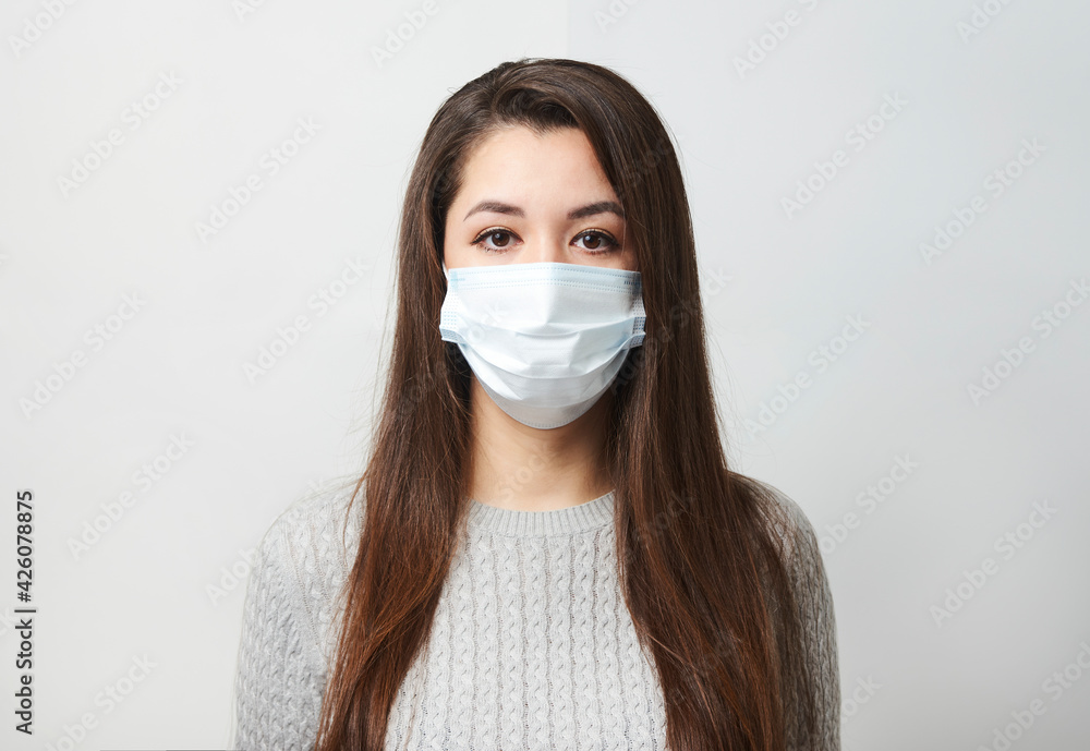 Young woman wearing medical mask, white background. Young woman wearing medical mask, white background.