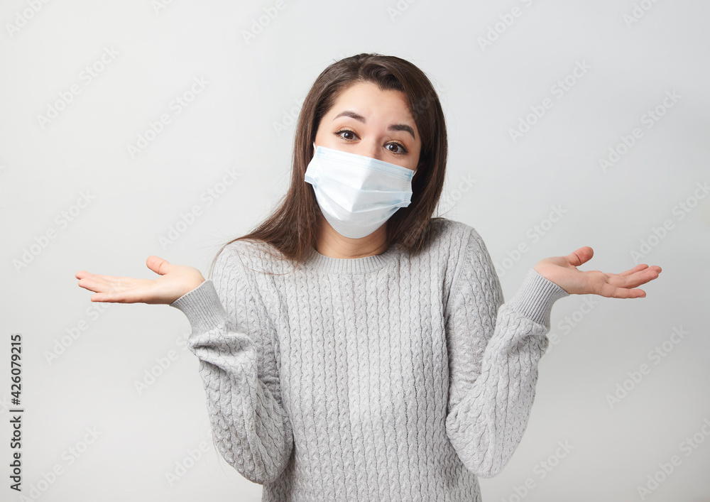 Young woman wearing medical mask, white background. Young woman wearing medical mask, white background.