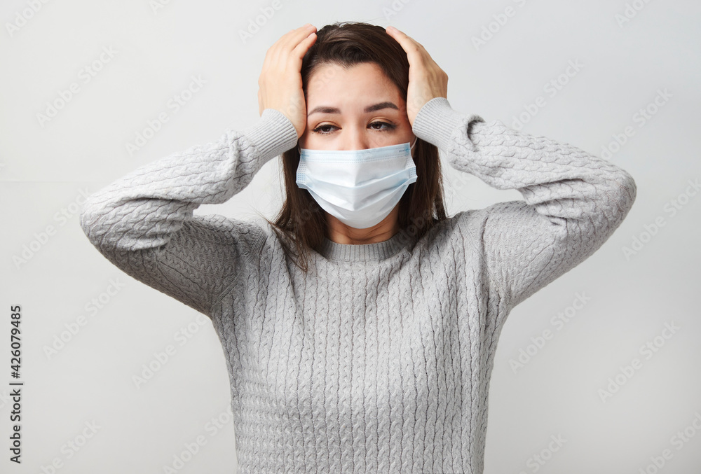 Young woman wearing medical mask, white background. Young woman wearing medical mask, white background.