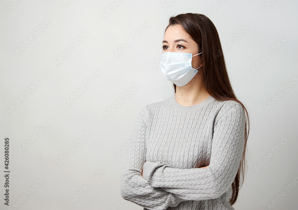 Young woman wearing medical mask, white background. Young woman wearing medical mask, white background.