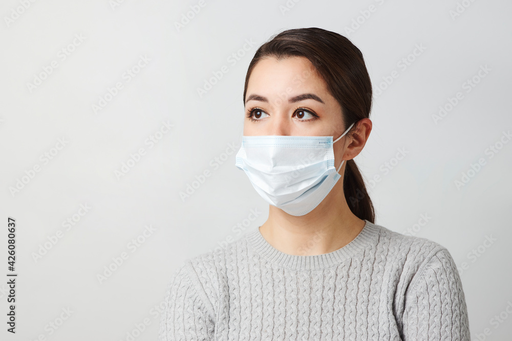 Young woman wearing medical mask, white background. Young woman wearing medical mask, white background.