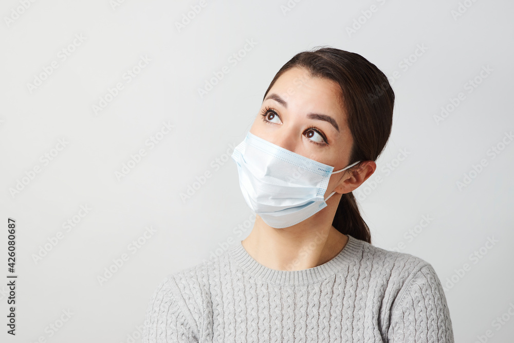 Young woman wearing medical mask, white background. Young woman wearing medical mask, white background.