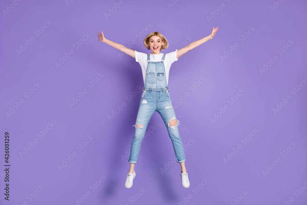 Obraz premium Full size photo of nice optimistic short hairdo blond lady jump wear white t-shirt overall isolated on violet background