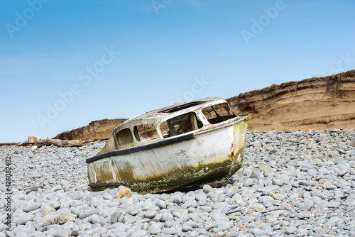 Ship wreck of an old boat washed up on a rocky beach