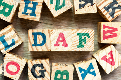 Alphabet letter block in word DAF (Abbreviation of Delivered at frontier) with another on wood background