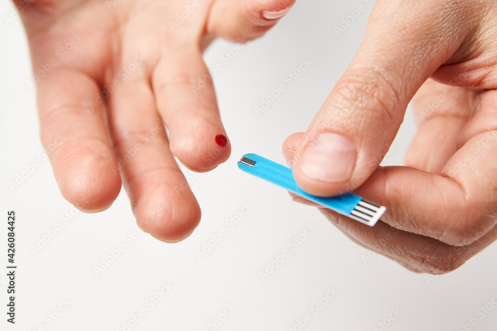 Woman with blood glucose meter, close-up Woman with blood glucose meter, close-up