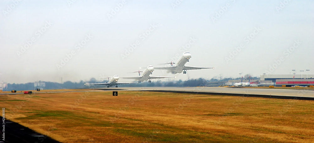 Composite images, airliner taking off concept. Hazy grey sky on a cloudy day. Spring grass, yellow and brown along the runway. Composite images, airliner taking off concept. Hazy grey sky on a cloudy day. Spring grass, yellow and brown along the runway.