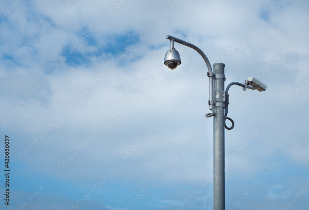 360 Degree fish eye dome CCTV and CCTV camera are installed on column against blue sky.