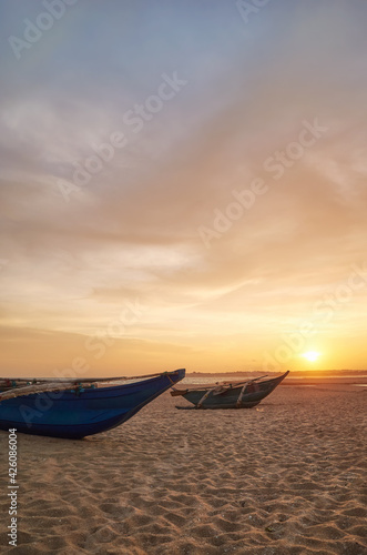 Small boats on an empty beach at sunset, Sri Lanka.