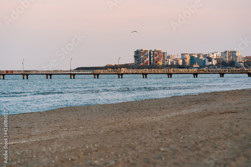 pier and city at sea at sunset