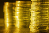 Group of golden coin stacking in vertical row shallow focus with fill in frame with gold coin blur background, rows of coins for finance and banking. finance and business concept.