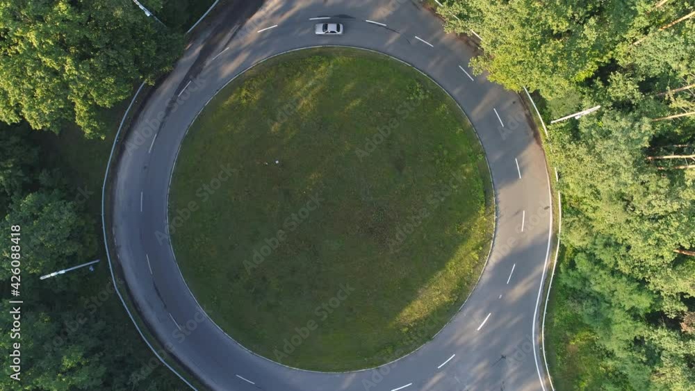 Car riding a roundabout in the forest. Top down aerial shot. Morning or evening Car riding a roundabout in the forest. Top down aerial shot. Morning or evening