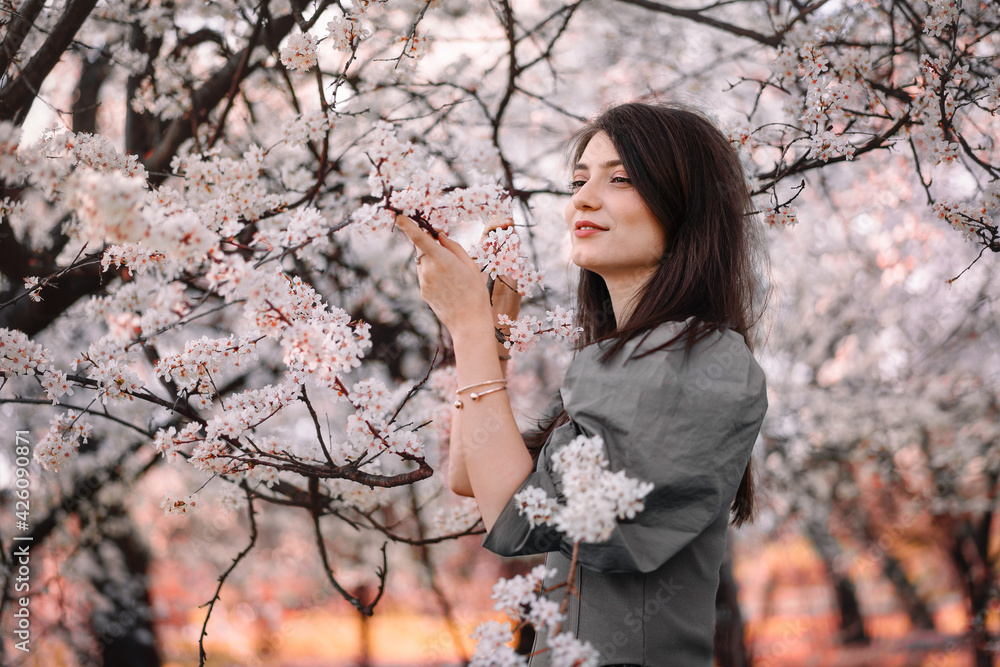 Beautiful young woman by blooming tree in spring Beautiful young woman by blooming tree in spring