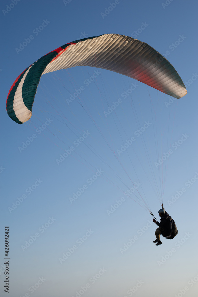 Paraglider flying over a cliff with blue sky, during the golden hour in Majorca. Paraglider flying over a cliff with blue sky, during the golden hour in Majorca.