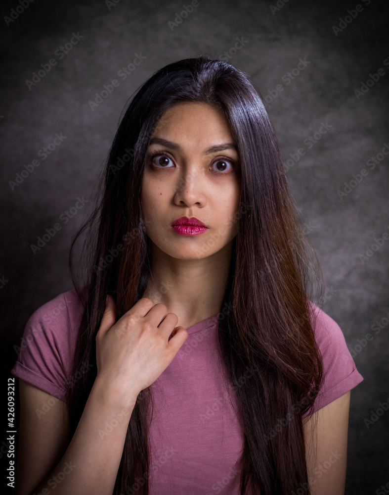 Pretty Asian woman - portrait shot against grey background - studio photography Pretty Asian woman - portrait shot against grey background - studio photography