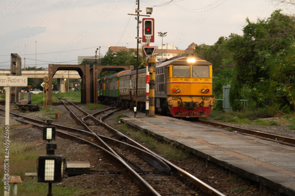 Fototapeta premium Locomotive train on railroad tracks from Thailand go into train station. Transport move passenger to station. Railway Tracks at a Major Train Station. traditional transport.