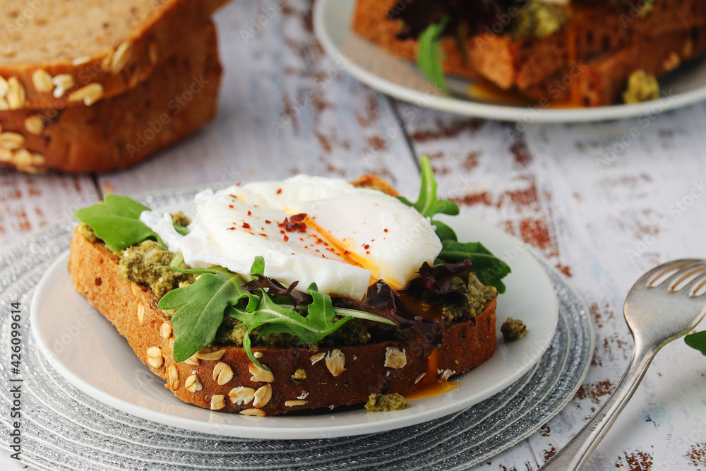 Homemade sandwiches with pesto, green salad and poached eggs Homemade sandwiches with pesto, green salad and poached eggs