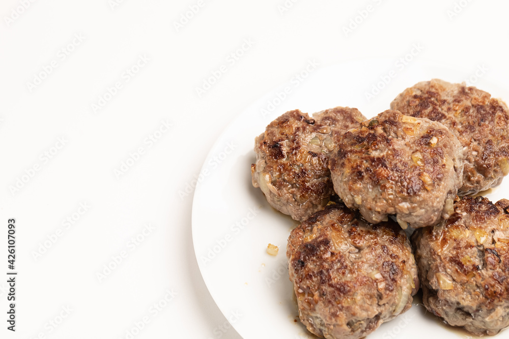 Ready-to-eat homemade beef cutlets. Appetizing cauldrons on a white plate on a white background. Ready-to-eat homemade beef cutlets. Appetizing cauldrons on a white plate on a white background.