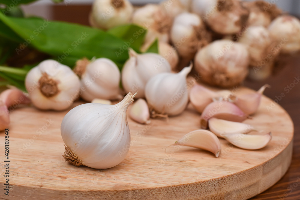 Garlic Cloves and Bulb on wooden cutting board. Garlic on wooden table background Garlic Cloves and Bulb on wooden cutting board. Garlic on wooden table background