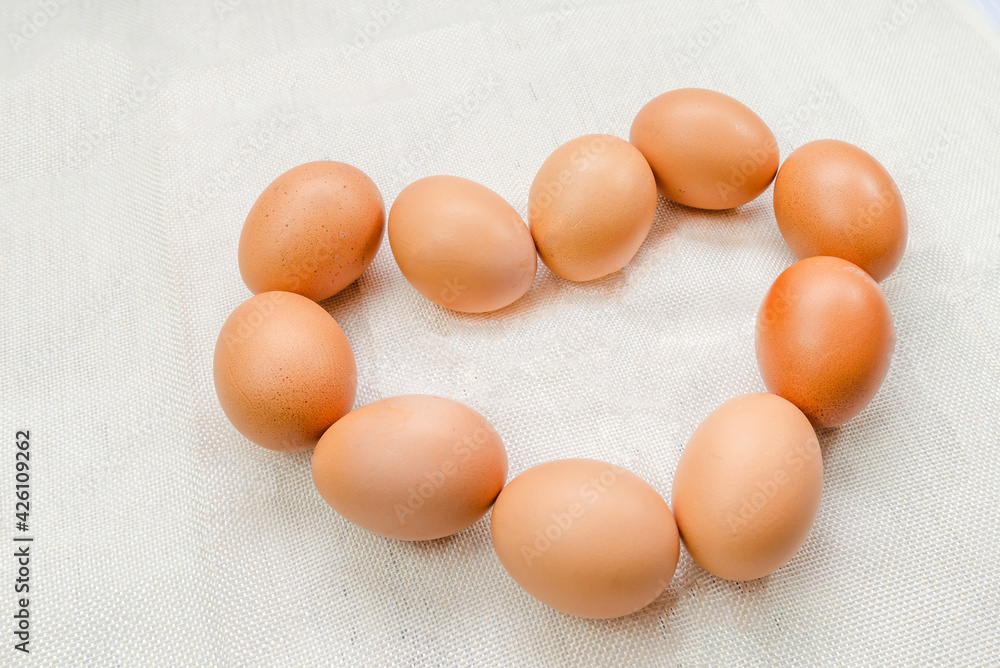 Chicken Egg with heart shape on sack background Chicken Egg with heart shape on sack background