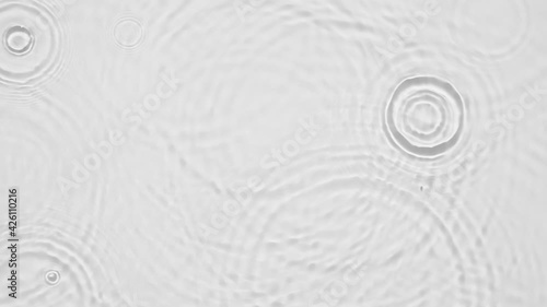 Up close, top view, Slow motion various waves of the water surface hitting the sun's rays, making them sparkle according to different patterns on a gray background video 4K.