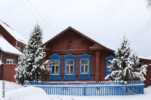 Vintage wooden rural house in Dunilovo village in Ivanovo region, Russia. Building facade; ornamental windows with carved frames. Russian traditional national folk style in architecture. Countryside photo