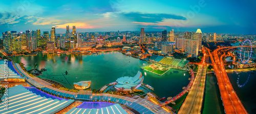 Singapore - May, 2018: Wide panorama at sunset and blue hour of Singapore Marina Bay with illuminated skyscrapers of the financial district in the downtown of the city. Singapore cityscape aerial view
