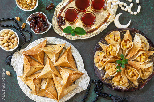 Arabic Cuisine. Ramadan Kareem Festive. Ramadan menu, of Egyptian oriental dessert: assorted arabian pancake katayef and dates, pistachio. Top view.