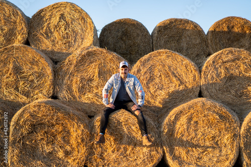 Cheerful, pretty and full of life guy enjoying a photoshoot in the straw photo