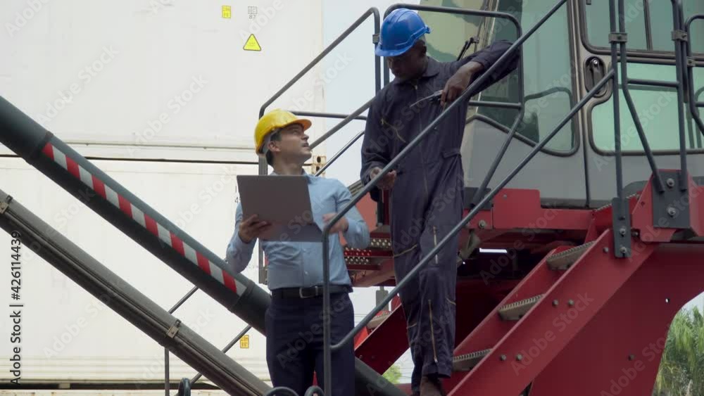 business man using laptop checking list inventory loading Containers box discussion with african american foreman diver on forklift at warehouse logistic in Cargo freight ship. diversity worker business man using laptop checking list inventory loading Containers box discussion with african american foreman diver on forklift at warehouse logistic in Cargo freight ship. diversity worker
