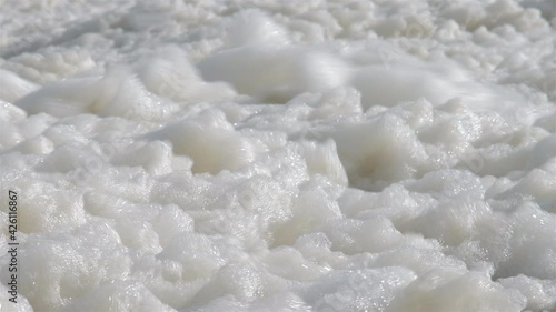 sea foam moving created by strong wind at the north sea, Scheveningen, Netherlands