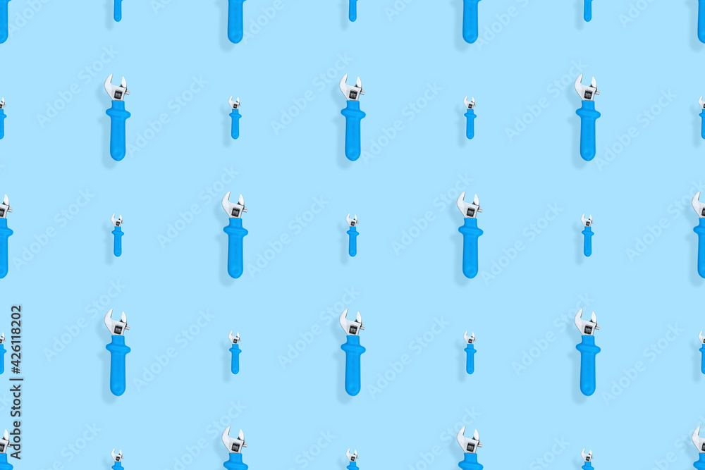 Background from a metal adjustable wrench with a rubber handle. Tools seamless pattern. Background from a metal adjustable wrench with a rubber handle. Tools seamless pattern.