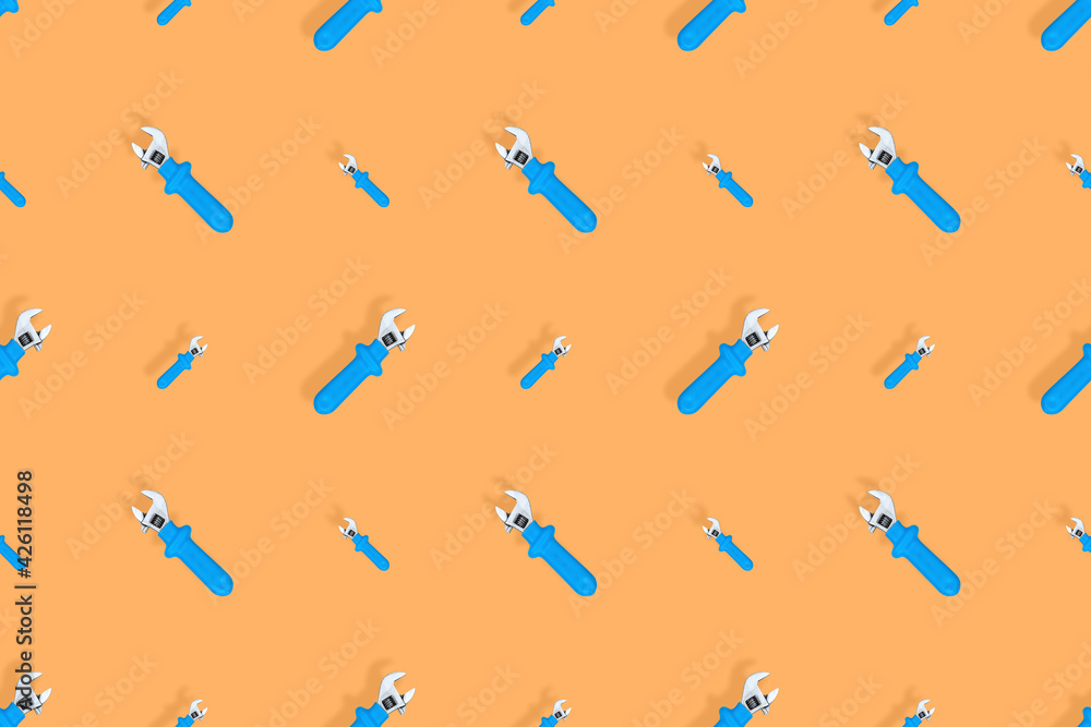 Background from a metal adjustable wrench with a rubber handle. Tools seamless pattern. Background from a metal adjustable wrench with a rubber handle. Tools seamless pattern.