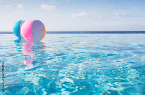 Beach balls floating on water in infinity pool photo