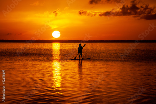 Stand up paddling into the sunset on the ocean