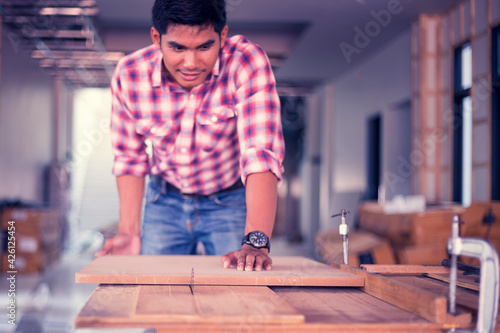 Portrait of a carpenter working happily in his shop. Creating a product from wood Happy work concept